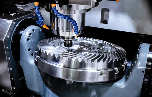 CNC-Fräsmaschine bearbeitet ein Kegelrad, Kühlmittelschläuche sind auf das Werkstück gerichtet